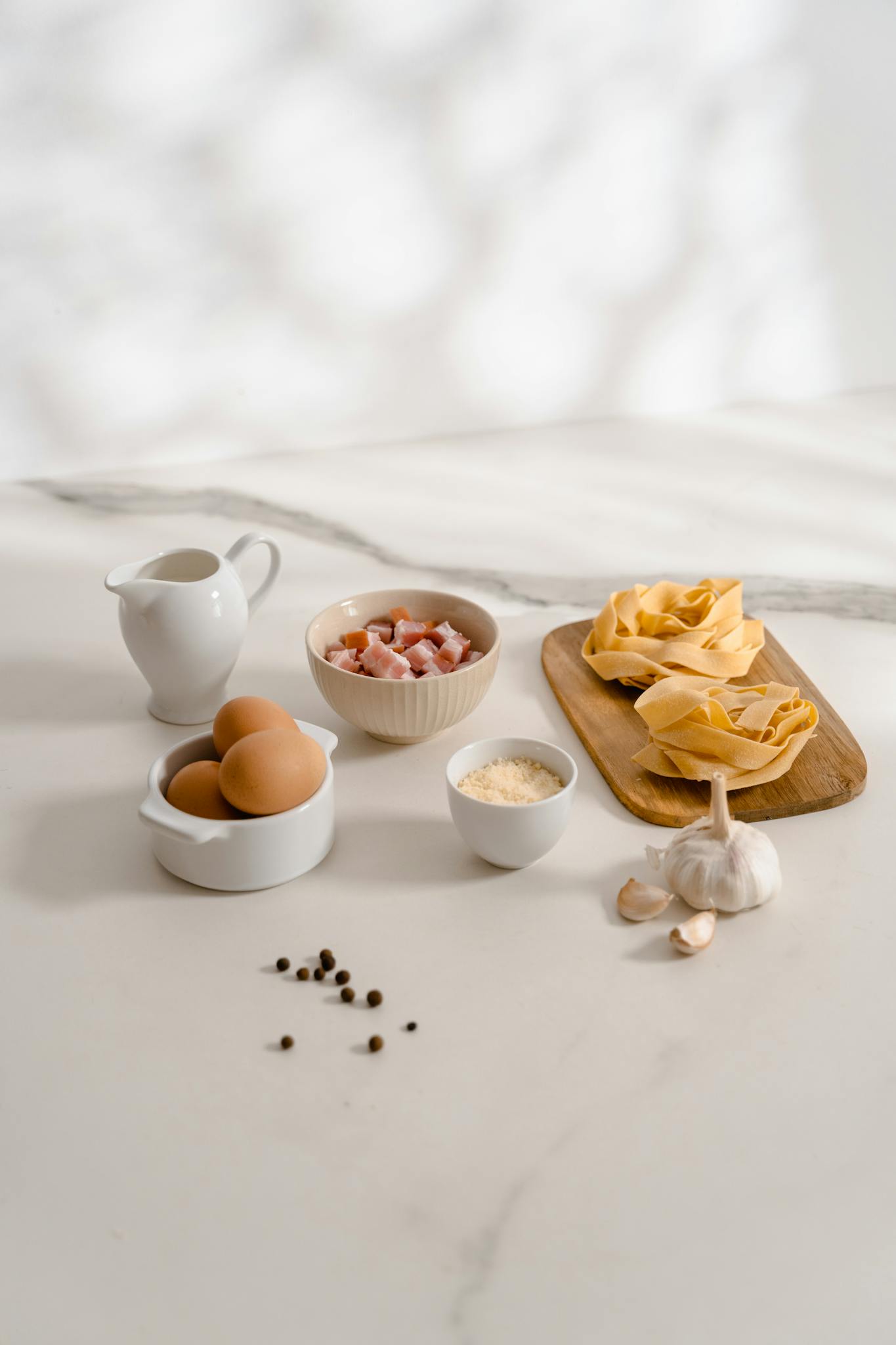 Aesthetic display of ingredients for homemade pasta carbonara recipe.