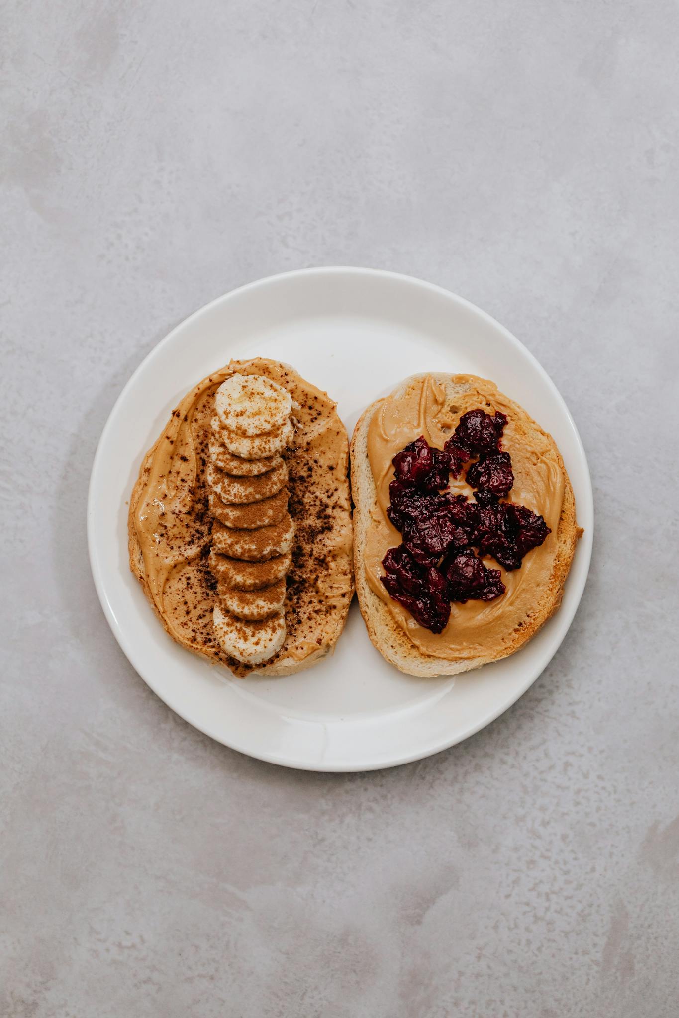 Delicious peanut butter toast topped with banana slices and berry jam, perfect for a healthy snack.